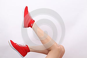 Woman`s legs with Red Tomy Takkie Trainers