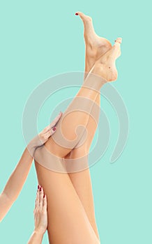 Woman`s legs with smooth skin after depilation on pastel background.