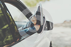 Woman`s legs in sneakers in the window car. Girl in jeans in the car with her legs crossed.