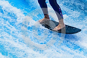 Woman`s legs standing on surfboard