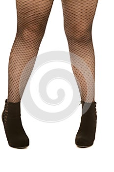 Woman's legs wearing fishnet stockings and high heels