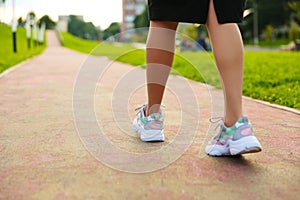 Woman`s legs wearing sport sneakers