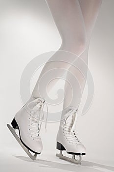 Woman's Legs in White Ice Skates