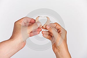 Woman`s and Man`s hands forming a heart shape from hearing aids