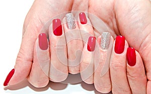Woman`s nails with beautiful red manicure fashion design with gems isolated