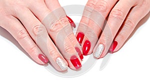 Woman`s nails with beautiful red manicure fashion design with gems isolated