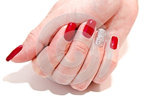 Woman`s nails with beautiful red manicure fashion design with gems isolated