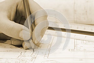 Woman`s palm holding pencil and architectural plans