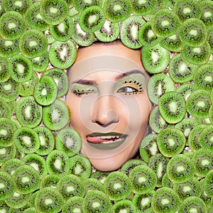 Woman's portrait with green kiwi closeup. Bright kiwi make up