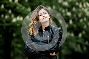 Close-up portrait of young beautiful Russian brunette girl at summer green park