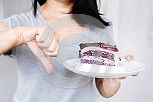 Woman's Resolute Gesture: Rejecting Sugar Temptation by Refusing to Indulge in Cake and Sweet Desserts