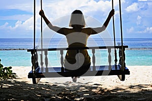 Woman's silhouette on a swing