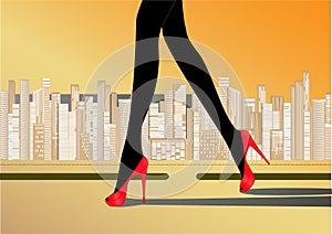 Woman`s slender legs in red high-heeled shoes walk on the road against the yellow background skyscrapers