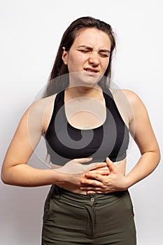 A woman`s stomach hurts. Abdominal pain due to gastritis, stomach ulcers and Crohn`s disease. Gastroenteritis, diarrhea or