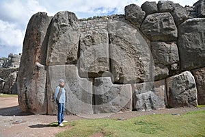 Woman and Sacsayhuaman Ruins, Cuzco, Peru.