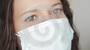 Woman with sad blue eyes in protective face mask, sadness, grief, stress and negative emotion during quarantine lockdown