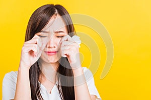 Woman sad she crying wiping tears from eyes with a tissue