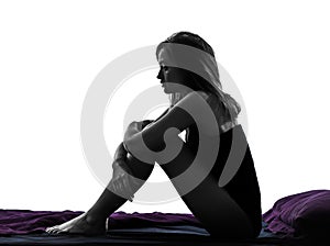 Woman sad despair sitting in bed silhouette
