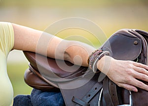 Woman with saddle in rural location