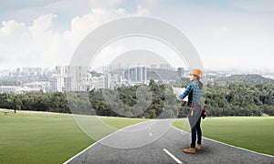 Woman in safety helmet standing on road