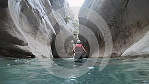 Woman in safety jacket enjoying extreme adventure hiking canyon river national park