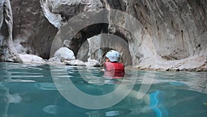 Woman in safety jacket enjoying extreme adventure hiking canyon river national park