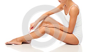 Woman with safety razor shaving legs