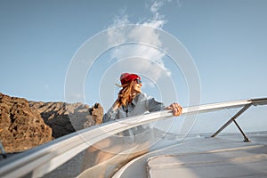 Woman sailing on the yacht near the rocky coast