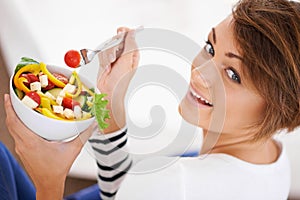 Woman, salad and happy portrait with healthy food for diet, detox and breakfast on sofa at home. Person relax and eating