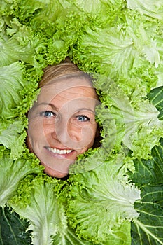 Woman with salal leafes around her head.