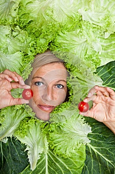 Woman with salal leafes around her head.
