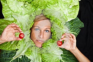 Woman with salal leafes around her head.