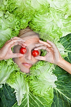 Woman with salal leafes around her head.