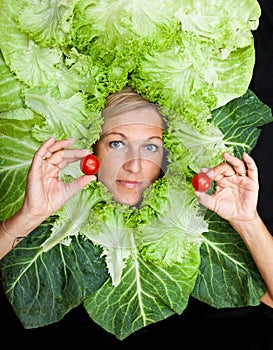 Woman with salal leafes around her head.