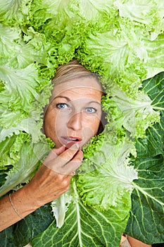 Woman with salal leafes around her head.