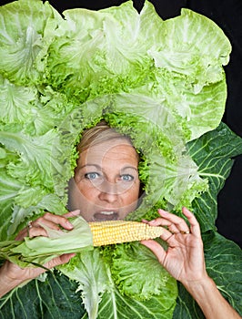 Woman with salal leafes around her head.