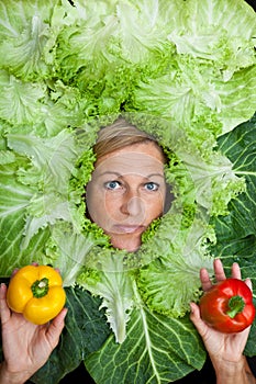 Woman with salal leafes around her head.