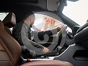 Woman salesperson asking to sign some documents at car dealership