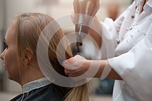 Woman in salon and hairdresser with a hairdryer