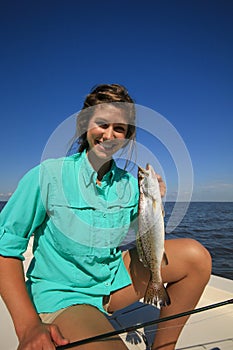 Woman Saltwater Fishing Holding a Speckled Trout in Louisiana