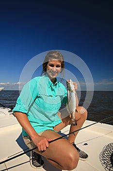 Woman Saltwater Fishing Holding a Speckled Trout in Louisiana