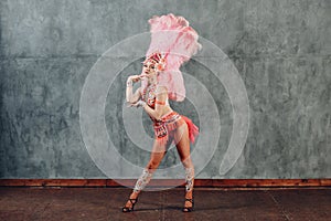 Woman in samba or lambada costume with pink feathers plumage