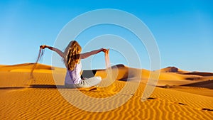 Woman through sand in the sahara desert with computer