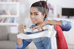 woman sandpapering wooden chair legs