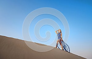 Woman in sands dunes of desert at sunset