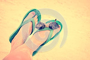 Woman sandy bare feet with flip flops and sunglasses, vintage style