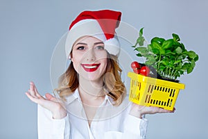 Woman in Santa Claus hat with basket of herbs