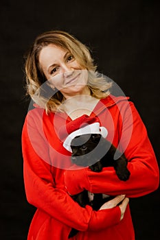 Woman in santa costume and puppy in santa hat