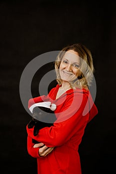 Woman in santa costume and puppy in santa hat