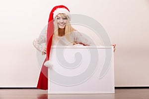 Woman in santa hat with blank banner. Copy space.